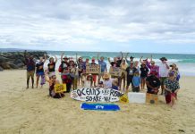 Surfers line the shore in solidarity